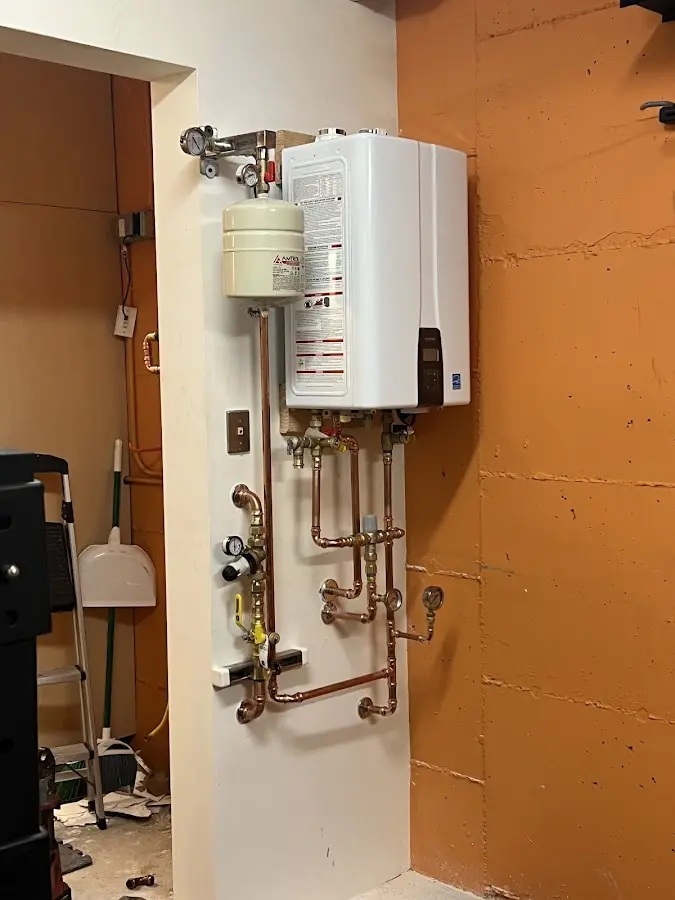 Plumbing technician inspecting water heater connections in Union